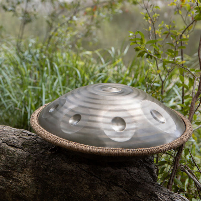 Handpan drum on a tree branch with a natural background
